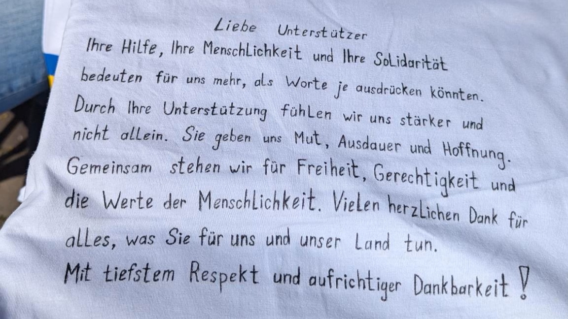 Handgeschriebener Dank auf einem weißen Stoff – bewegende Worte über Freiheit, Menschlichkeit und Hoffnung.