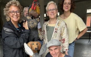 Beate Müller-Gemmeke mit vier weiteren Personen im Albgut Münsingen – lachend um eine Holzskulptur der Bremer Stadtmusikanten versammelt.