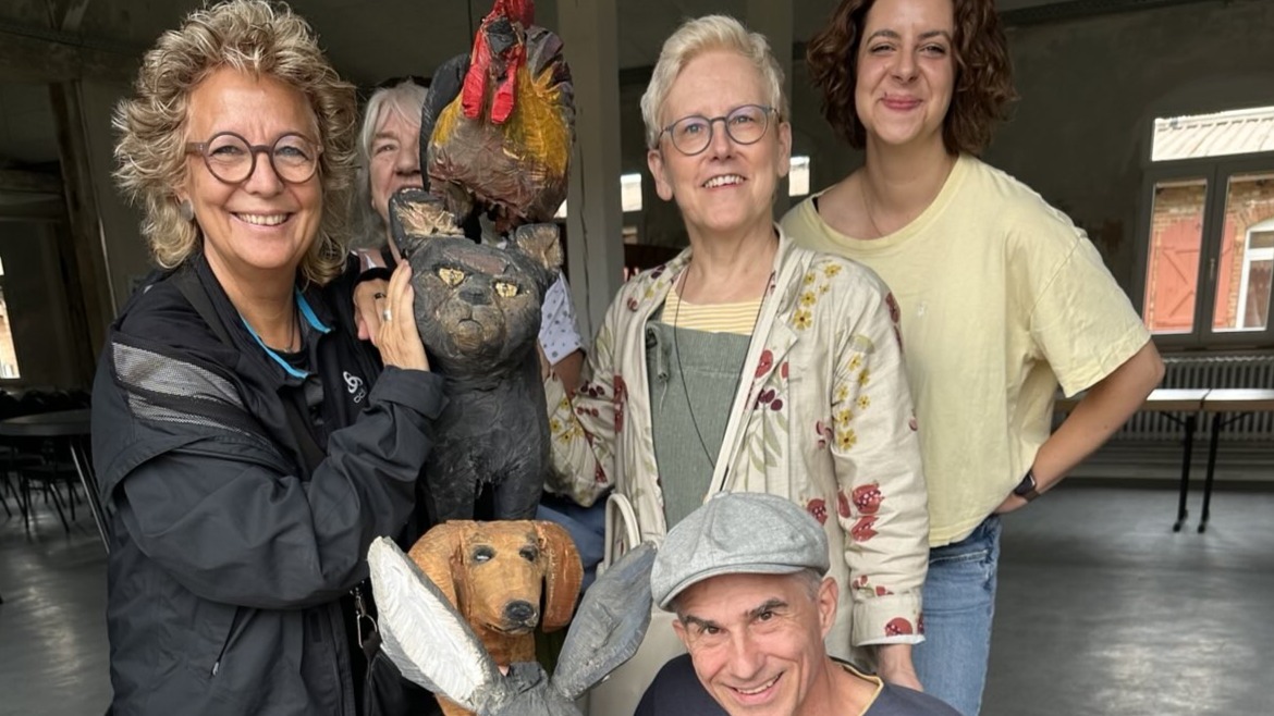 Beate Müller-Gemmeke mit vier weiteren Personen im Albgut Münsingen – lachend um eine Holzskulptur der Bremer Stadtmusikanten versammelt.