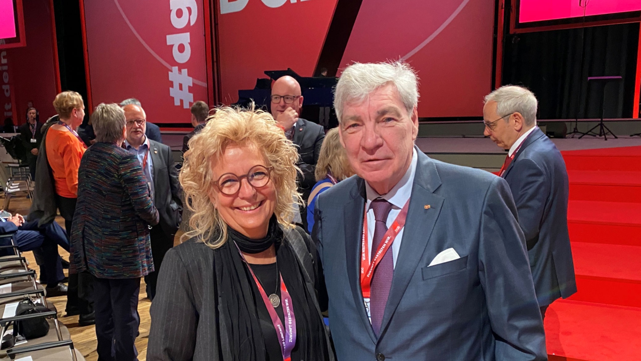 Beate Müller-Gemmeke mit Michael Sommer, ehemaliger Vorsitzender des Deutschen Gewerkschaftsbundes (DGB), beim DGB-Bundeskongress. Beide tragen Namensschilder und Tagungsbändchen, im Hintergrund das rote Bühnenbild mit DGB-Logo.