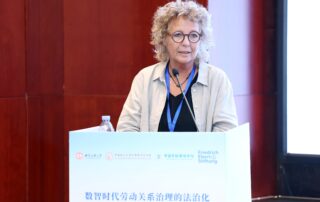 Beate Müller-Gemmeke beim Vortrag auf der internationalen Arbeitsrechtskonferenz in Chengdu am Rednerpult, im Hintergrund das Logo der Friedrich-Ebert-Stiftung.
