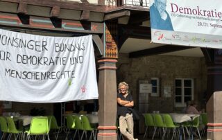 Banner mit der Aufschrift „Münsinger Bündnis für Demokratie und Menschenrechte“ beim Demokratiefest in Münsingen; davor Beate Müller-Gemmeke.