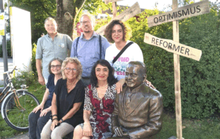 Gruppenfoto mit Beate Müller-Gemmeke, Muhterem Aras und weiteren Teilnehmenden an der Statue von Matthias Erzberger in Münsingen.
