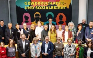 Gruppenfoto des Gewerkschafts- und Sozialbeirats von Bündnis 90/Die Grünen im Bundestag vor einem bunten Banner mit der Aufschrift „Gewerkschafts- und Sozialbeirat“. In der Mitte: Beate Müller-Gemmeke mit Vertreterinnen und Vertretern aus Gewerkschaften, Sozialverbänden und Politik.