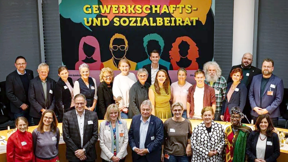 Gruppenfoto des Gewerkschafts- und Sozialbeirats von Bündnis 90/Die Grünen im Bundestag vor einem bunten Banner mit der Aufschrift „Gewerkschafts- und Sozialbeirat“. In der Mitte: Beate Müller-Gemmeke mit Vertreterinnen und Vertretern aus Gewerkschaften, Sozialverbänden und Politik.