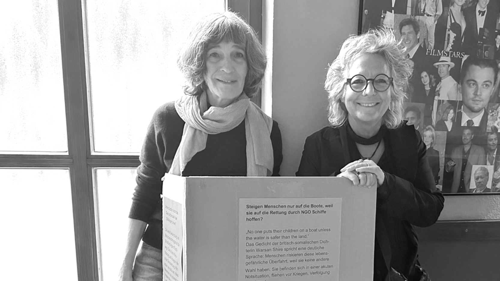 Katharina Kirchgeßner von der Seebrücke Reutlingen und Beate Müller-Gemmeke im Kino Luna in Metzingen. Im Foyer informieren sie mit einer Ausstellung über die Streichung der Mittel für zivile Seenotrettung.
