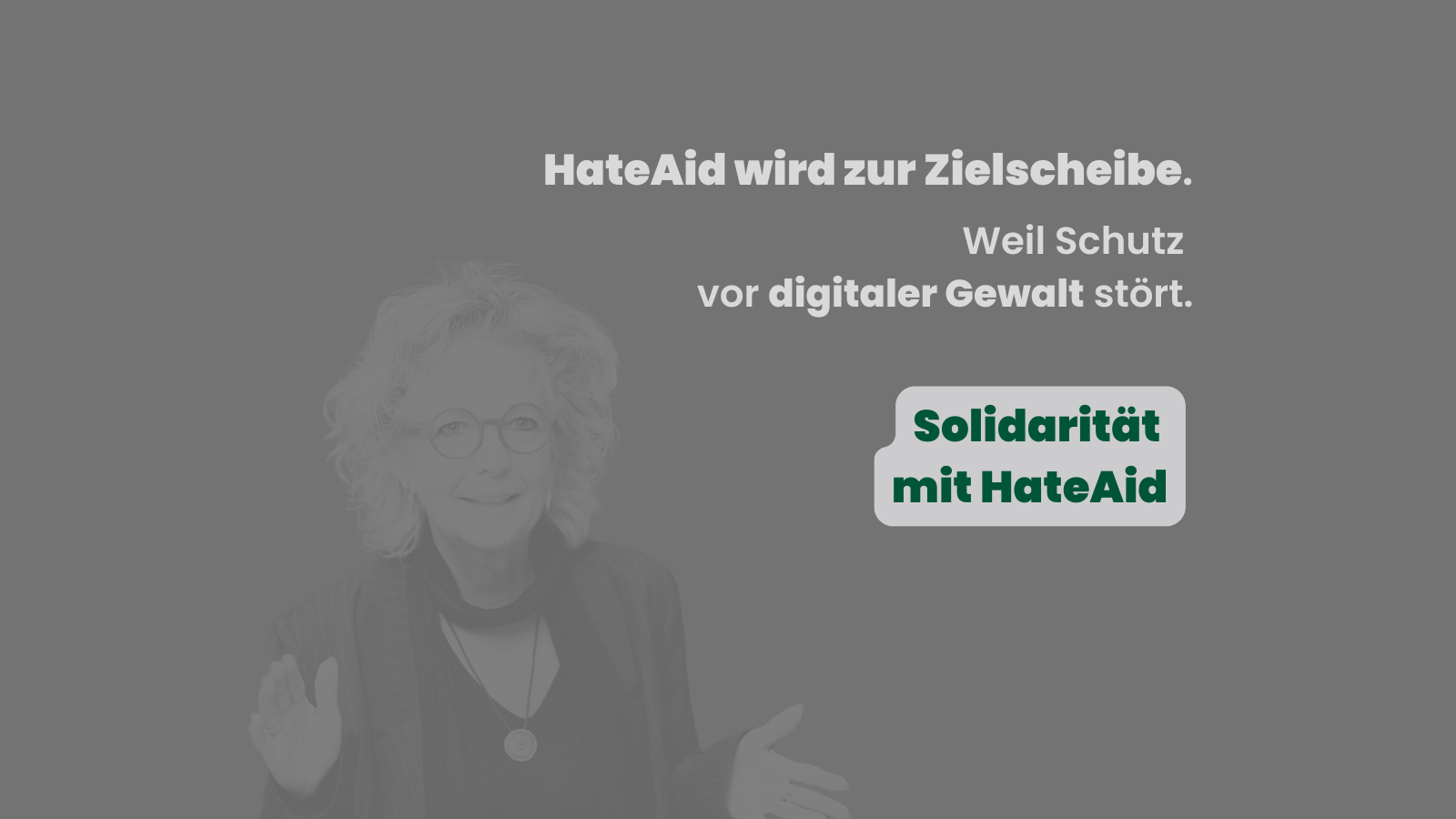Graues Sharepic mit Porträt von Beate Müller-Gemmeke im Hintergrund. Darauf der Text: „HateAid wird zur Zielscheibe. Weil Schutz vor digitaler Gewalt stört.“ Rechts steht in dunkelgrüner Schrift auf hellgrauem Hintergrund: „Solidarität mit HateAid“.
