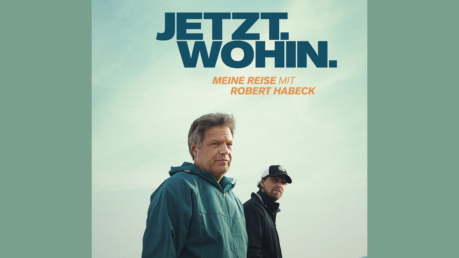 Filmplakat zu JETZT. WOHIN. Meine Reise mit Robert Habeck. Robert Habeck und Regisseur Lars Jessen stehen am Wasser, Blick in die Kamera. Der Himmel ist leicht bewölkt, der Hintergrund zeigt See und Uferlinie. Der Titel des Films steht groß oben im Bild.
