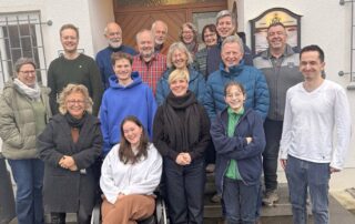 Gruppenfoto der Grünen aus Metzingen vor dem Naturfreundehaus. In der Mitte steht Beate Müller-Gemmeke und Cindy Holmberg zusammen mit Frauen und Männern unterschiedlichen Alters. Die Gruppe lächelt in die Kamera und zeigt eine offene, freundliche Atmosphäre nach einem gemeinsamen Klausurtag.
