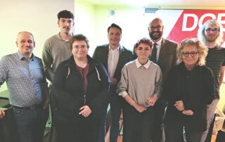 Gruppenfoto beim DGB-Podium „Wahlopoly“ in Hechingen: Mehrere Podiumsteilnehmende – auch Beate Müller-Gemmeke - stehen nebeneinander im Veranstaltungsraum. Im Vordergrund ist ein großes Spielbrett auf dem Boden zu sehen, angelehnt an das Monopoly-Spiel. Im Hintergrund hängt ein rotes DGB-Banner. Die Atmosphäre wirkt konzentriert und offen.