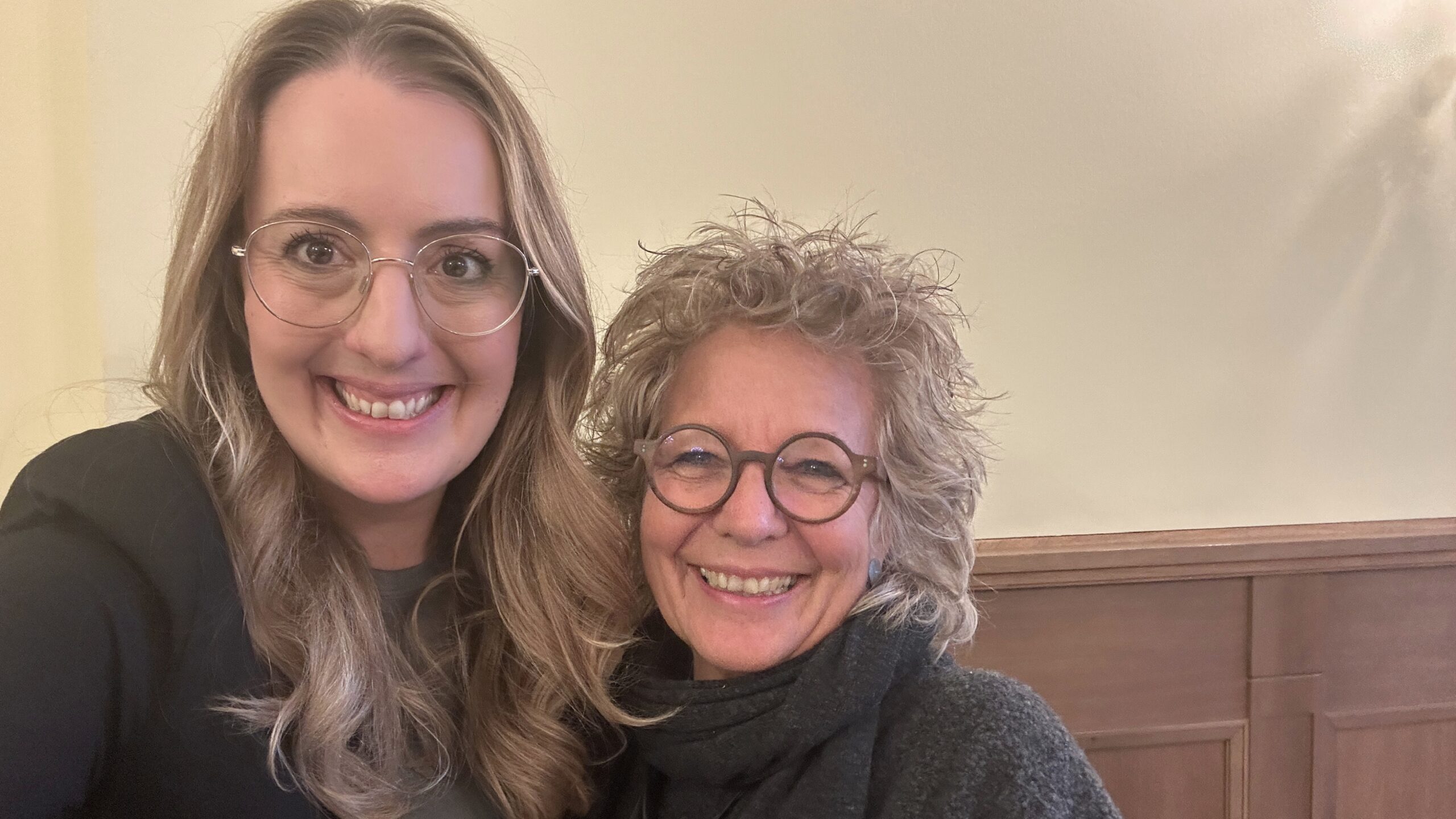 Beate Müller-Gemmeke und Fraktionsvorsitzende Katharina Dröge lächeln in die Kamera. Beide tragen dunkle Kleidung, im Hintergrund ein heller Innenraum. Aufnahme bei einem politischen Austausch in Berlin.