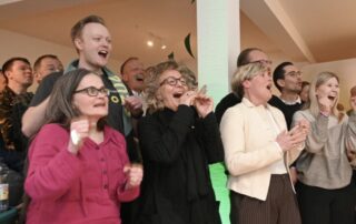 Beate Müller-Gemmeke und Cindy Holmberg klatschen und jubeln mit anderen Grünen bei der Wahlfete, nachdem das Ergebnis der Landtagswahl bekannt wird.