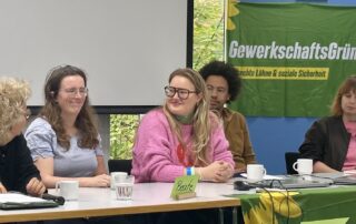 Beate Müller-Gemmeke sitzt mit Vertreter der Grünen Jugend und Sarah Gonschorek am Podium der Jahrestagung von GewerkschaftsGrün. Die Teilnehmenden diskutieren über gute Arbeitsbedingungen, gewerkschaftliche Organisierung und den gemeinsamen Beschluss für faire Arbeit bei Essenslieferdiensten.